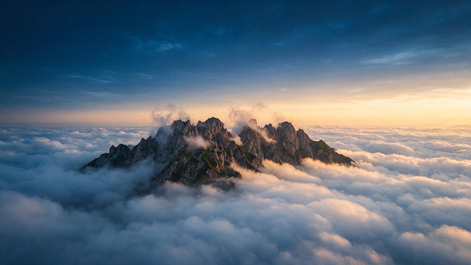 A mountain ridge above a sea of clouds at dawn